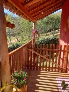 a wooden porch with stairs and flowers on it at Chalés Encantos de Cunha Vermelho in Cunha