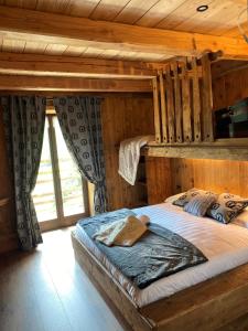 una camera con un letto in una baita di tronchi di FORESCH HUS CHAMBRES D'HOTES a Gressoney-Saint-Jean