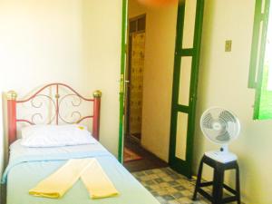 1 dormitorio con 1 cama y ventilador junto a una puerta en Hostel da Providência, en Salvador
