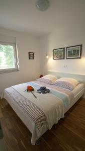 - une chambre blanche avec un lit fleuri dans l'établissement Apartment Lea - Lara, à Nin