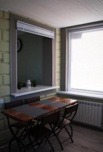 a dining room with a table and a window at Дом на берегу Новоладожского канала in Berezhnyye Lopatitsy