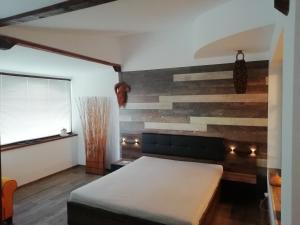 sypialnia z drewnianą ścianą i łóżkiem w obiekcie Ema guest house w Warnie