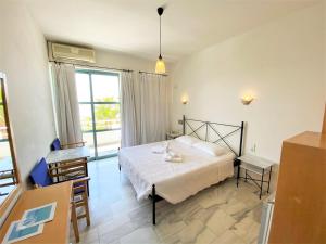 a bedroom with a bed and a table and chairs at Hotel Plakures in Falasarna