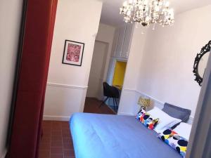 カルカソンヌにあるLe 9 de Cour, Chambre Kiwiのベッドルーム(青いベッド1台、シャンデリア付)
