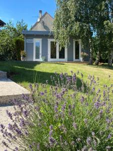 un jardín con flores púrpuras frente a una casa en Moulin Room en Naours