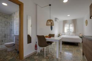 a bedroom with a bed and a desk and a bathroom at Finca Feliz Andaluz in Alora