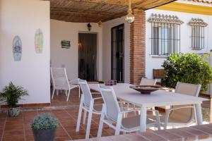 una mesa blanca y sillas en un patio en Finca Feliz Andaluz en Alora