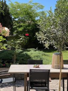 einen Holztisch mit zwei Stühlen und einem Baum in der Unterkunft La Collinière in Sainte-Gemme-Moronval