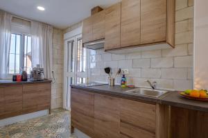 a kitchen with wooden cabinets and a sink at Finca Feliz Andaluz in Alora