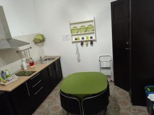 einen grünen Stuhl in einer Küche mit Spüle in der Unterkunft B&B Epicarmo in Augusta