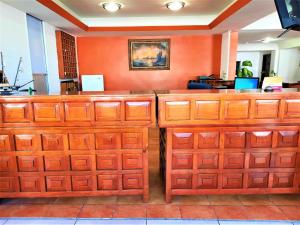 a large wooden counter in a room with orange walls at Hotel Costa Maria in Ciudad del Carmen
