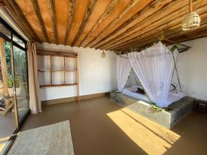 een kamer met een bed met gordijnen en een raam bij Eden Rock Zanzibar in Mtende