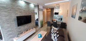 salon z telewizorem na murze z cegły w obiekcie Apartment Relax w Świnoujściu