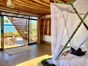 a bedroom with a bed with a view of the ocean at Eden Rock Zanzibar in Mtende