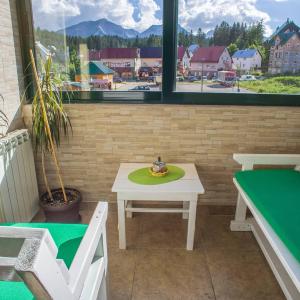 stół z miską na górze obok okna w obiekcie GLORIA Apartman w mieście Žabljak