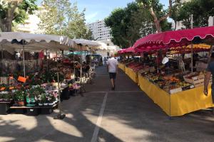 un homme qui passe devant un marché agricole avec des fruits et des légumes dans l'établissement La petite oasis, newly renovated, à Toulon