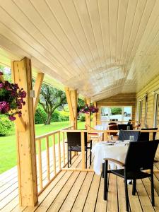 eine Holzterrasse mit einem Tisch und Stühlen darauf in der Unterkunft Bridge View House B&B and Restaurant in Kilcrohane