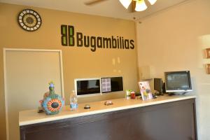 an office with a desk and a clock on the wall at Hotel Bugambilias in Ciudad Obregón