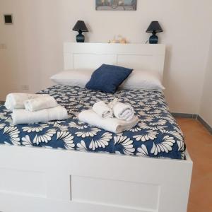 ein weißes Bett mit Handtüchern darüber in der Unterkunft I 23 PASSI GAETA in Gaeta