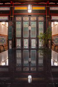 a door in a restaurant with a plant in front of it at Kinmenhouse of Old Tiles No 4 in Jincheng