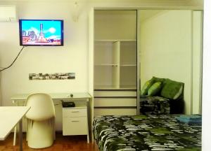 1 dormitorio con 1 cama y TV en la pared en Isla Verde en Rosario