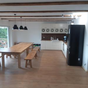 cocina grande con mesa de madera y bancos en Mazurska Stodola, en Dłużec