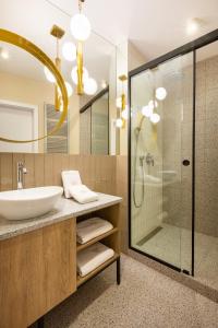 a bathroom with a sink and a shower at Fragola Apartments Vistula View in Kraków