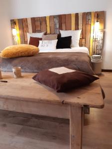 1 dormitorio con 1 cama grande sobre una mesa de madera en La Pause, en Plombières