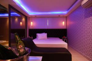 a room with a bed and a bottle of beer at LESSENCE MOTEL in São Paulo