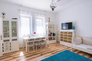 a white living room with a table and a couch at Kőfejtő háza in Fertőrákos