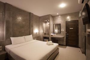 
A bed or beds in a room at Ritsurin Boutique Hotel - SHA Plus
