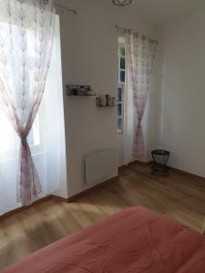 a bedroom with a bed and a window with curtains at Appartement Dali centre historique Perpignan in Perpignan