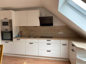 a kitchen with white cabinets and a sink at Ferienwohnung Madeleine in Haiger +6 photos