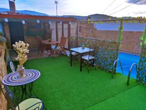 a patio with green grass and a table and chairs at Casa Conesa II in Tronchón