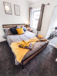 ein Schlafzimmer mit einem großen Bett mit gelber Bettwäsche in der Unterkunft 'Number 11' Central Colchester - Super Convenient 2 x Double Bed 1 x Single Bed Cottage PLUS Office & Garden, 8 min walk Nth Station & Town Ctr, 2 min walk local shops & restaurants in Colchester