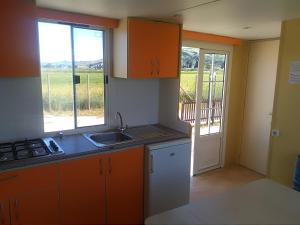 a kitchen with orange cabinets and a sink and a window at VILLAGGIO degli ANGELI SCERNE PINETO in Scerne