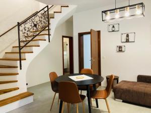 - un salon avec une table et des chaises ainsi qu'un escalier dans l'établissement Family House Apartma, à Mozirje