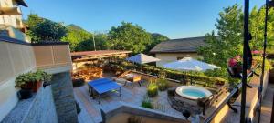 an outdoor patio with a hot tub and tables and umbrellas at La Terrazza Casa Vacanza in Carenno