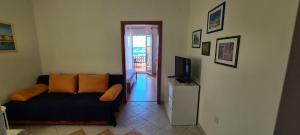 a living room with a couch and a television at Adria Arba Apartments in Rab