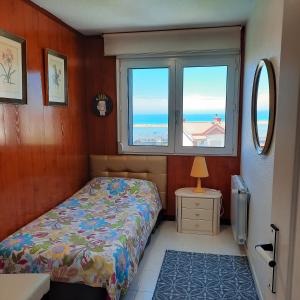 1 dormitorio con cama y ventana en Adosado con vistas al mar los GIRASOLES en Mogro