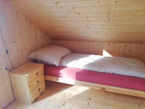 a bed in a cabin with a wooden floor at Domek Bażant in Kołczewo