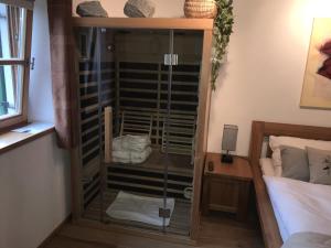 eine Glasdusche in einem Schlafzimmer mit einem Bett in der Unterkunft Golfchalet Uttlau in Bad Griesbach