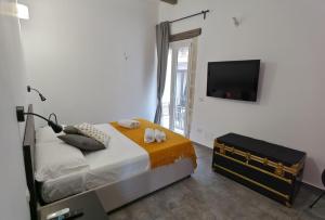 1 dormitorio con 1 cama y TV de pantalla plana en Cavour 45 - Ortigia apartments, en Siracusa