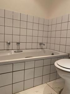 ein weißes Bad mit einer Badewanne und einem WC in der Unterkunft Critchley Hackle Dullstroom Towers in Dullstroom