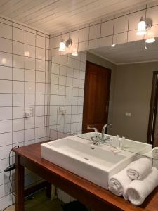 ein Badezimmer mit einem weißen Waschbecken und einem Spiegel in der Unterkunft Critchley Hackle Dullstroom Towers in Dullstroom