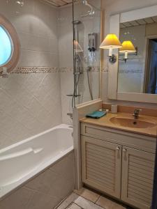 La salle de bains est pourvue d'une baignoire, d'un lavabo et d'une douche. dans l'établissement la baie des voiles ,vue lac d'Annecy ,plage privée, à Duingt