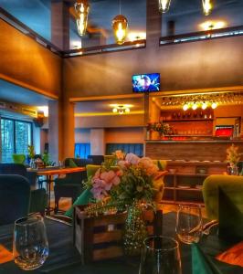 a restaurant with a table with a vase of flowers at Вила АРБОРЕТУМ in Teteven