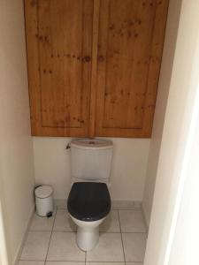 a bathroom with a toilet with a wooden cabinet at Demeure Saint Martin in Sourdun +23 photos