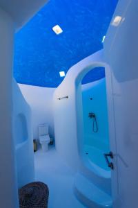 a bathroom with a toilet and a blue ceiling at Amma Houses Sea View in Kalafatis