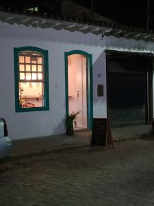 een wit gebouw met een raam en een deur bij Com Verso e Prosa RePouso e Café in Paraty
